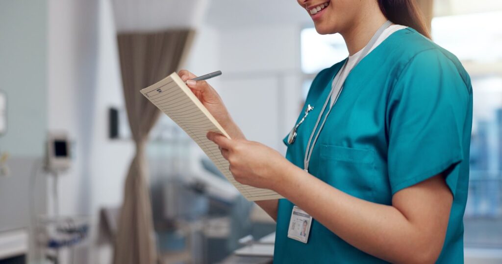 A nurse updates patient notes on a chart, ensuring continuity of care and informed treatment decisions.