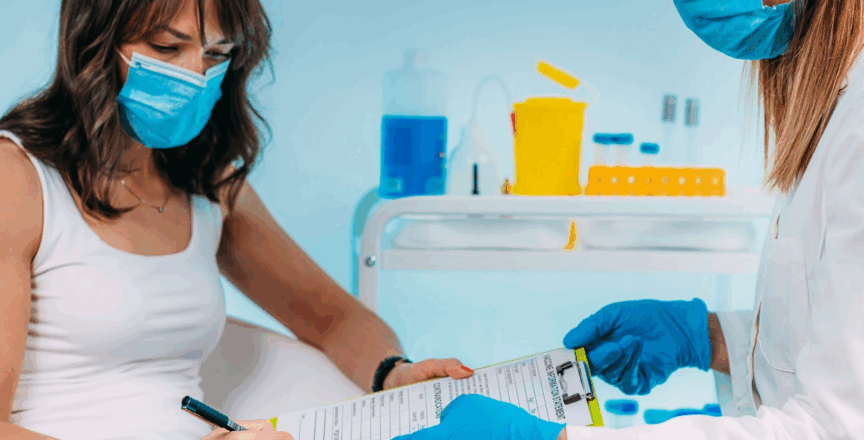 Nursing holding out a form for a patient to sign.